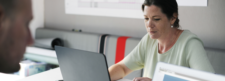 Woman in light green top working at laptop in modern office