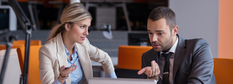 Business professionals in serious discussion seated on orange chairs in modern office