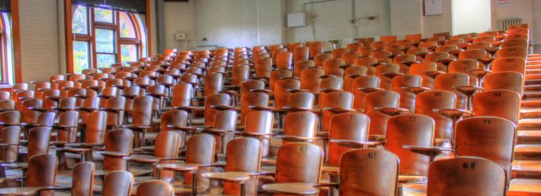 Empty traditional lecture hall with vintage wooden theater seats in steep rows