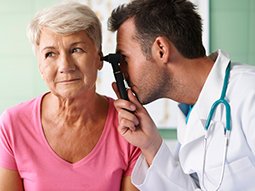 Otolaryngologist examining ears with ENT tuning fork of young patient