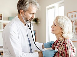 Cardiologist taking EKG test of senior patient